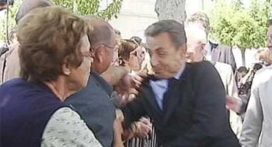Sarkozy aan zijn jasje getrokken